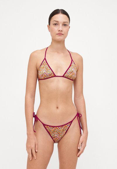 Bikini set s vzorovaným vrškem a spodkem. Trojúhelníkový tvar, vícebarevný cik-cak design a vínové akcenty. Zavazuje se na bocích.