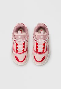 Une paire de baskets FILA roses et rouges avec des lacets blancs, vue de dessus sur un fond blanc uni.