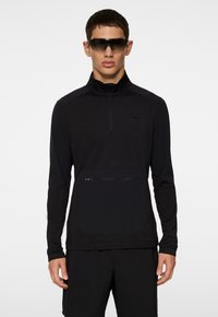 Svart zip-up långärmad tröja med ståkrage, med en ficka fram med dragkedja, slät textur och minimalistisk design.