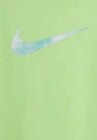 Zielona bawełniana koszulka z dużym, wyblakłym niebieskim logo swoosh Nike na przodzie. Gładka tekstura z okrągłym dekoldem.