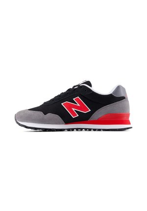 Black and gray sneaker with red accents and a large red "N" logo on the side, white midsole, and black rubber outsole.