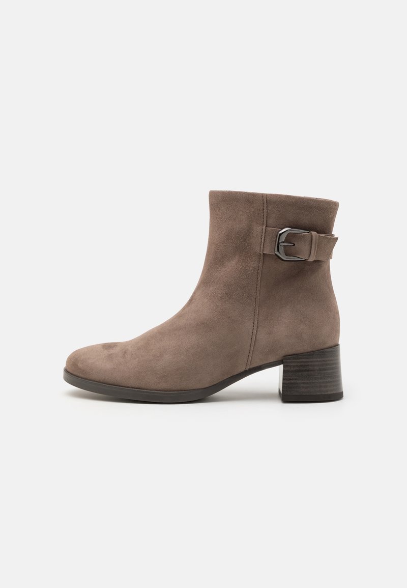 Bottine en daim taupe avec petit talon bloc et boucle décorative latérale sur fond uni.
