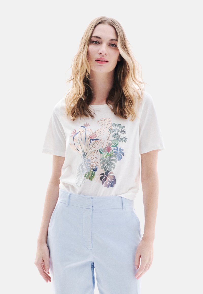 Witte katoenen t-shirt met kleurrijk botanisch en luipaardprint ontwerp. In combinatie met lichtblauwe op maat gemaakte broek. Zachte textuur, korte mouwen.