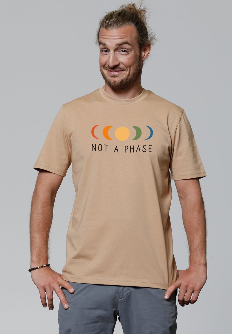 Beige T-Shirt mit kurzen Ärmeln und einem Rundhalsausschnitt, der ein gedrucktes Design von farbigen Mondphasen über dem Text "NICHT EINE PHASE" zeigt.
