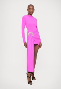 Rochie fucsia cu mânecă lungă, cu un corp ajustat și un detaliu drapat pe lateral, accentuat de un element metalic circular. Material neted și elastic.