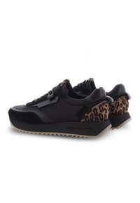 Svarta sneakers med slätt läder, mockadetaljer och en leopardmönstrad baksida. Strukturad gummisula med zigzagmönster.