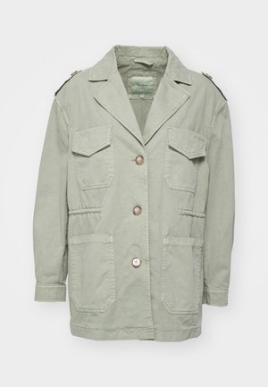 Gaiši zaļa jaka ar vaļēju piegulumu, kurai ir atslēgas formas apkakle, četri priekšējie kabatas un pogu aizdare. Izgatavota no mīksta teksturēta auduma.