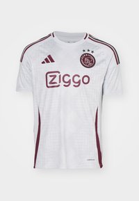 Hvid fodboldtrøje med maroon accenter, zigzag mønster og adidas-logo. Har "Ziggo" i maroon og tre stjerner over et våbenskjold.