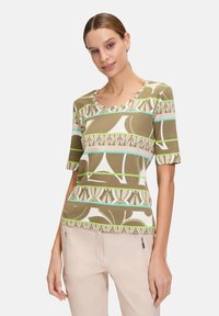 Short-sleeve top in textured knit, featuring an abstract pattern in green, white, and light blue, with a round neckline and relaxed fit.
