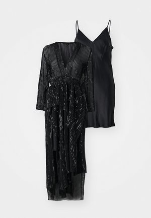 Czarny zestaw sukienek składający się z długiej warstwy zewnętrznej ozdobionej cekinami, z głębokim dekoltem w kształcie litery V oraz czarnej satynowej sukienki na cienkich ramiączkach.