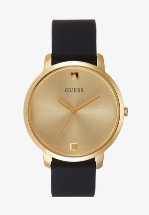 Montre-bracelet Guess ton or avec bracelet en cuir noir, cadran minimaliste effet rayons de soleil et index simples aux positions 12 et 6 heures.