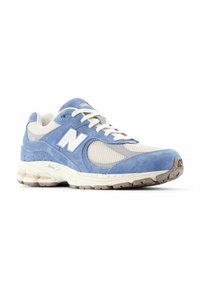 Blue suede and mesh sneaker with cream accents, featuring a white logo, round laces, and a textured sole for grip.