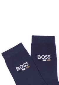 Granatowe skarpetki wykonane z miękkiego materiału, z haftowanym słowem "BOSS" w kolorze białym, czarnym i brązowym po bokach.