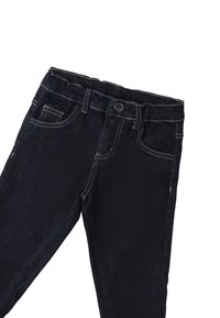 Jeans de mezclilla azul oscuro con acentos de costura, diseño de cinco bolsillos y cremallera. Cuenta con un cierre de botón y una pierna ligeramente ajustada.