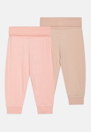 Twee paar zachte, elastische taillebandbroeken, één in lichtroze en één in beige, met aansluitende boorden en een gladde, effen textuur.
