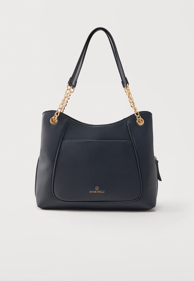 Sac à main en cuir noir texturé avec poche avant, chaîne dorée et bandoulières en cuir, avec logo « Anna Field » à l'avant.