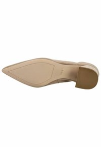 Chaussure à talons hauts en suede nude, avec un bout pointu, un décolleté lisse et une semelle en caoutchouc texturé comportant des rainures horizontales.