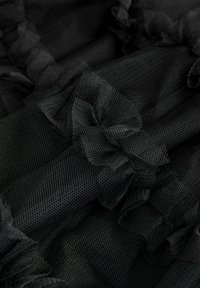 Mustor tüllkangas tekstureeritud pinna ning rüüdedetailidega, millel on kogu ulatuses meshtüüpi muster. Pehme, kerge ja läbipaistev.