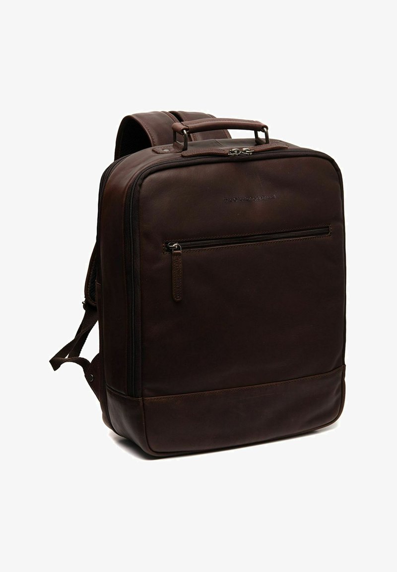 Sac à dos en cuir marron au design plat, avec une poignée supérieure, des bretelles ajustables et une poche zippée à l'avant. Texture lisse et accents minimalistes.