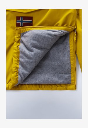 L'intérieur de la veste jaune présente un doux doublage en polaire grise et une poche zippée. Un patch de drapeau norvégien est cousu à l'extérieur.