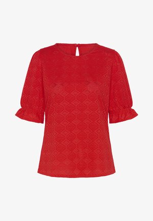 Červená blúzka s krátkym rukávom a geometrickým čipkovaným vzorom, okrúhlym výstrihom s malým otvorom na chrbte a volánikovými lemami rukávov.