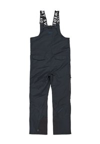 Salopette impermeabile nera con bretelle regolabili, numerose tasche e gambe inferiori rinforzate realizzate in un tessuto testurizzato.