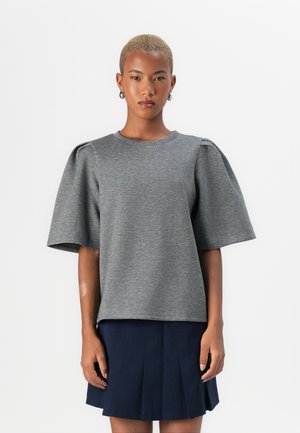 Grijze korte mouwen pullover met een ronde hals en pofmouwen, gemaakt van zacht materiaal, gecombineerd met een donkerblauwe geplooide rok.
