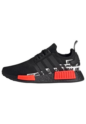 Czarny but sportowy Adidas z czerwonymi akcentami na śródpodeszwie, białym wzorem logo Adidas na pięcie oraz czarnym wzorem trzech pasków po boku.