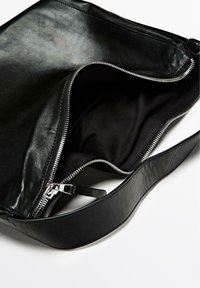 Zwarte leren tas met een ritsluiting en een gladde textuur. Beschikt over een brede schouderband en een ruime, donkere stoffen binnenkant.