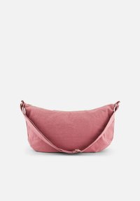 Sac à bandoulière en tissu rose avec une forme courbée, une surface texturée, une fermeture éclair et une longue sangle ajustable. Aucun motif visible ni accent de matériel.