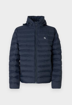 Μπουφάν navy blue με διακοσμητική ραφή, πλήρες φερμουάρ και κουκούλα. Διαθέτει μικρό λογότυπο στο στήθος και υφή υφάσματος.