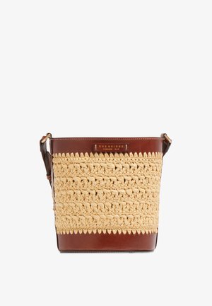 Bolso estilo cubo con tejido beige trenzado y detalles en cuero marrón, con una correa para el hombro y una pequeña etiqueta frontal con el logo.