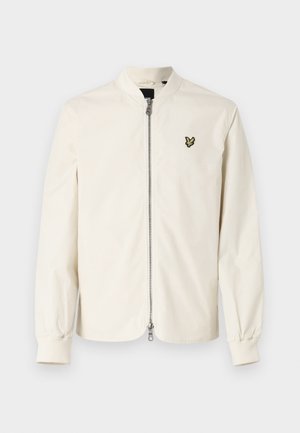 Giacca bomber bianca con zip frontale, polsini a costine e un piccolo logo verde sul petto. Tessuto liscio con una sensazione leggera.