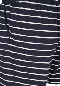 Námořnické modré trenýrky s bílými horizontálními pruhy, s elastickým páskem a bočními kapsami, vyrobené z měkké, prodyšné bavlny.