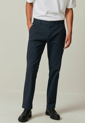 Marineblaue Hosen aus leichtem Stoff, mit geradem Bein, zwei seitlichen Taschen, einem einzelnen Knopfverschluss und subtiler Textur.