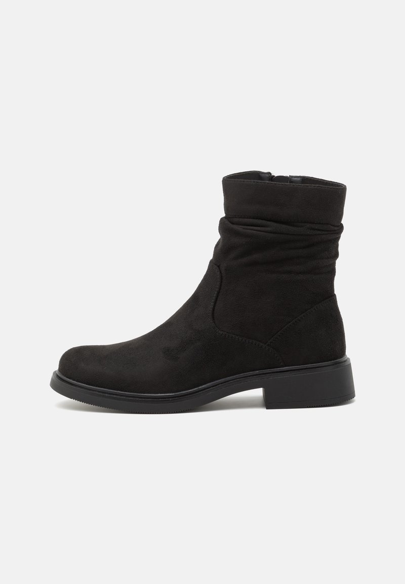 Botte noire en daim mi-mollet avec talon bloc bas, bout rond et partie supérieure ample sur fond blanc uni.