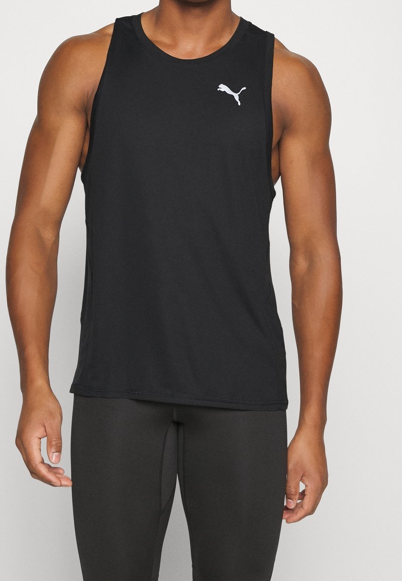 Débardeur de sport noir sans manches en tissu léger, avec un col rond et un logo Puma blanc sur le côté gauche de la poitrine.