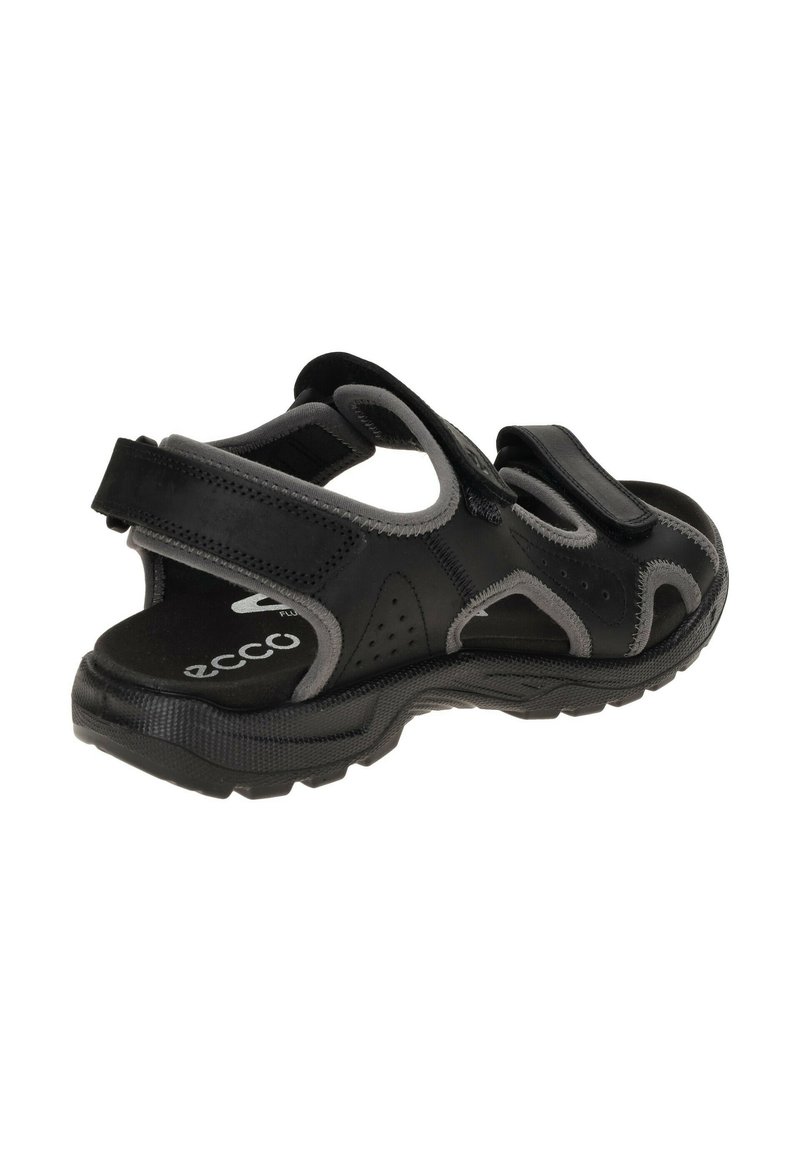 Sandale athlétique noire avec accents gris ; elle dispose de sangles Velcro réglables, d'un design ouvert, d'une semelle en caoutchouc texturé et d'un dessus perforé pour la respirabilité.