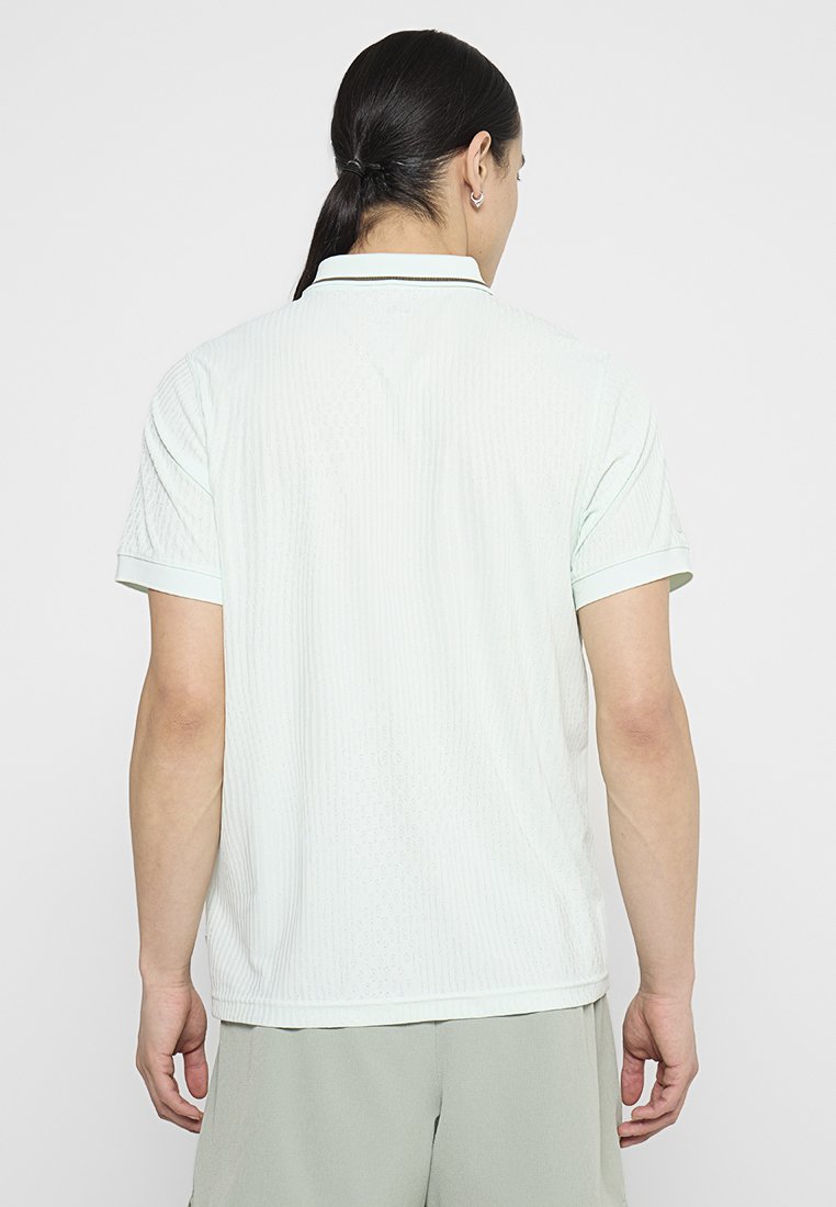 Hellgrünes Poloshirt mit strukturierter Musterung, kurzen Ärmeln und kontrastierendem Kragen. Bietet eine lässige Passform und dezente Rippdetails.