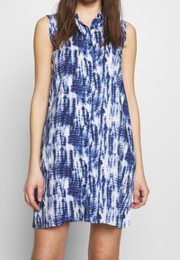 Abito senza maniche, con bottoni, in un motivo tie-dye blu e bianco, in cotone, con una vestibilità leggermente rilassata, colletto e chiusura frontale con bottoni.