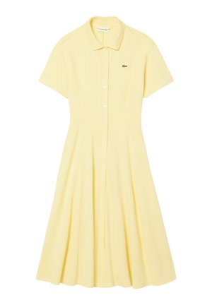 Robe à manches courtes, jaune pâle, boutonnée avec col et petit logo de crocodile vert brodé sur la poitrine.