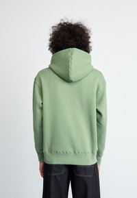 Sweatshirt com capuz na cor verde menta, feito de um tecido suave. Apresenta um corte descontraído, punhos e uma cintura canelada, com um capuz grande.