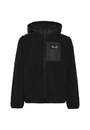 Blond dziecko stojące, ubrane w czarną polarową kurtkę z kapturem, czarne wodoodporne spodnie oraz czarne buty na jednolitym białym tle.