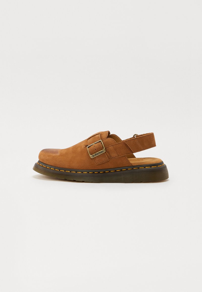 Rudų zomšinių apkabos batų su reguliuojamu sagtimi, paminkštintu padu ir guminiu padu, kuriame yra kontrastinga geltonos siūlės detalė.