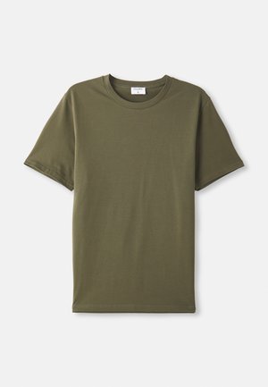 T-shirt simples de manga curta, cor verde oliva, disposto em plano sobre um fundo branco.