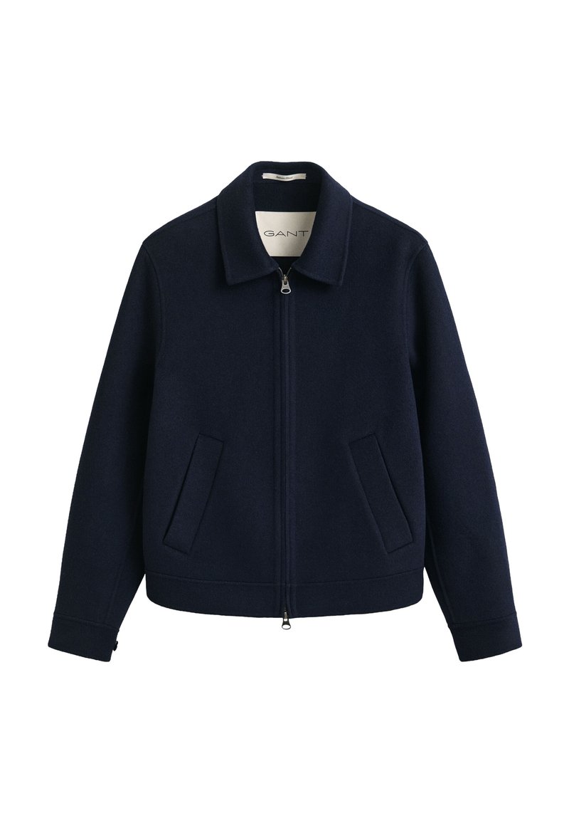 Giacca in lana blu navy con zip, collo e due tasche frontali inclinate, mostrata su sfondo bianco.