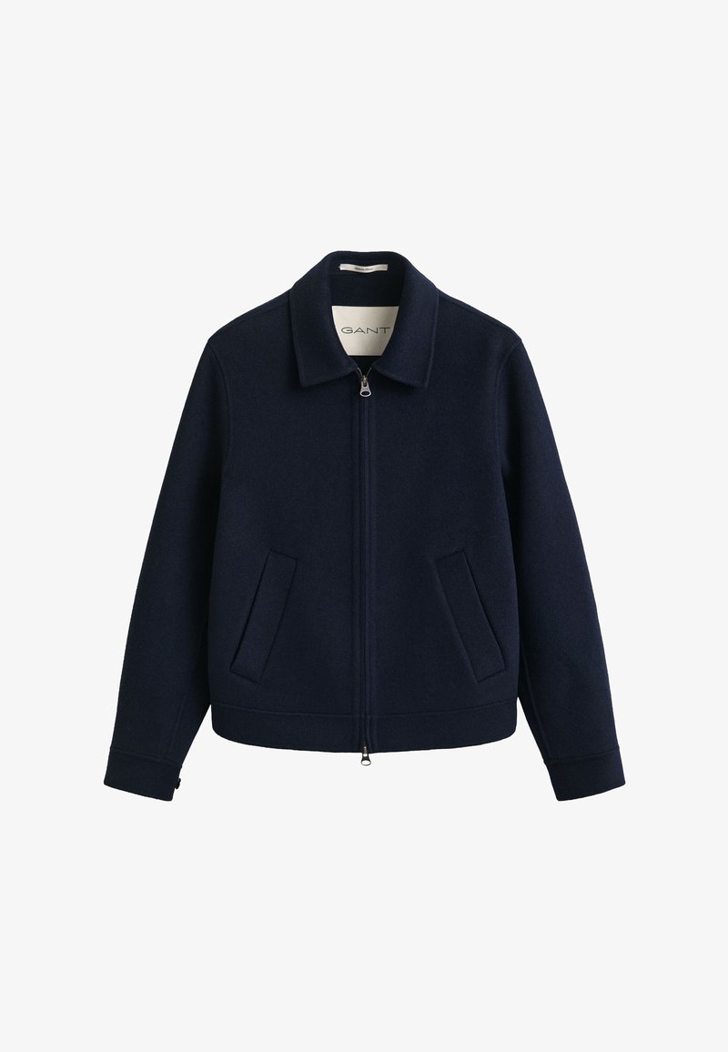 Giacca in lana blu navy con zip, collo e due tasche frontali inclinate, mostrata su sfondo bianco.