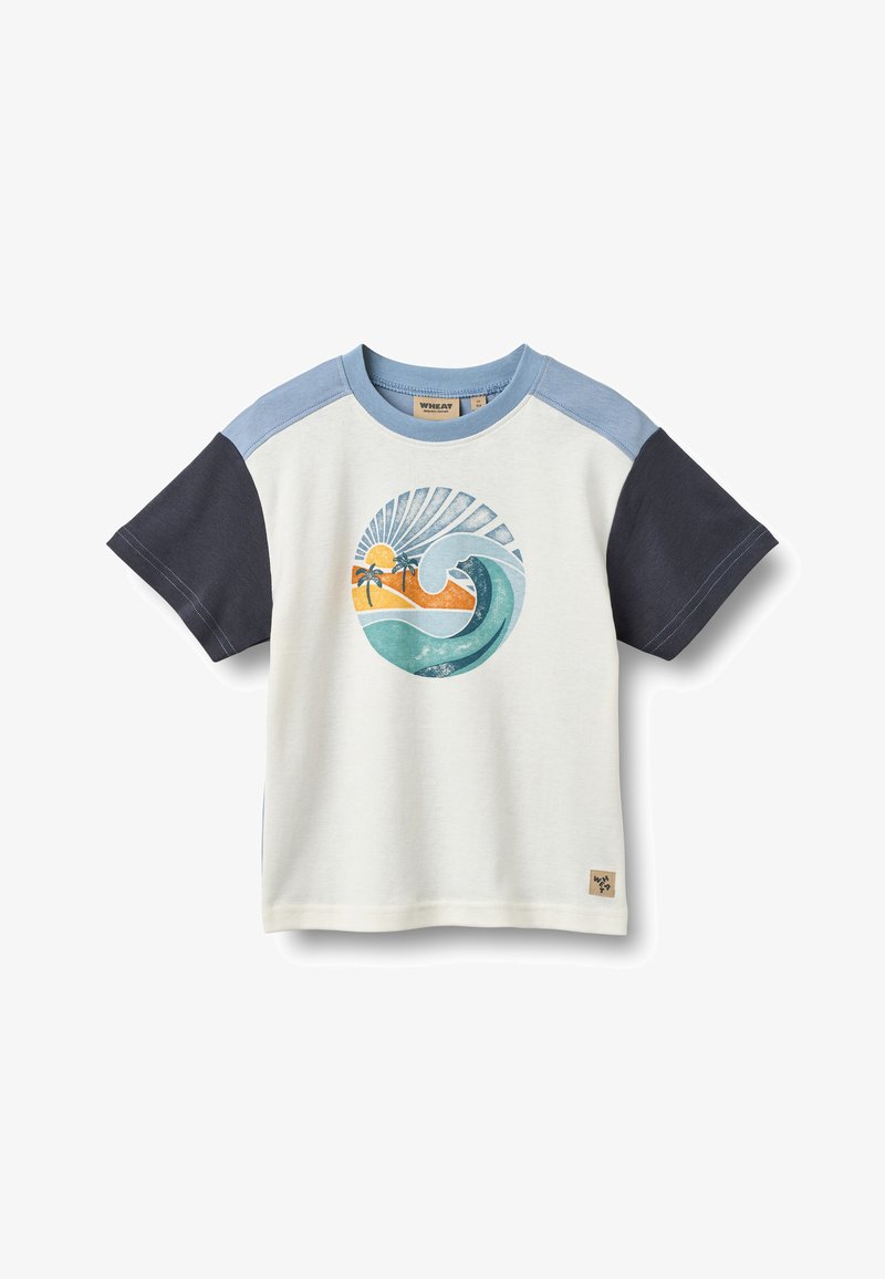 T-shirt à manches courtes couleur crème clair avec manches bleu et marine. Présente un motif vague et coucher de soleil en turquoise, orange et jaune. Étiquette à l'ourlet.