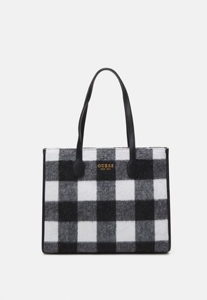 Black and white checkered tote bag made of felt, featuring black synthetic handles and gold "GUESS EST 1981" logo on the front.