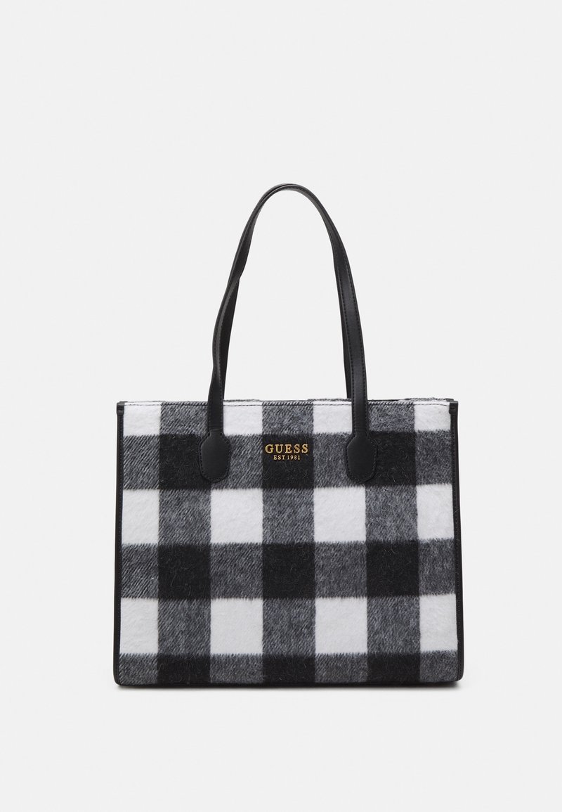 Sac fourre-tout à carreaux noir et blanc en feutre, doté de poignées synthétiques noires et d'un logo doré "GUESS EST 1981" à l'avant.